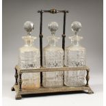 A GOOD THREE BOTTLE CUT GLASS TANTALUS, with three whisky decanters and stoppers.