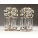 A PAIR OF GLASS CANDLESTICKS, with lustre drops and circular bases.