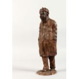 A MOULDED TERRACOTTA FIGURE OF A MAN, signed. 11ins high.