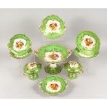 A GOOD APPLE GREEN PART DESSERT SERVICE, edged in gilt and painted with fruit, comprising comport,