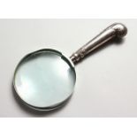 A MAGNIFYING GLASS, with silver pistol handle.