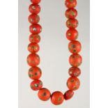 A SET OF RED COLOURED BEADS.