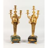 A GOOD PAIR OF EMPIRE DESIGN GILT BRONZE THREE LIGHT FIGURAL CANDLESTICKS, on marble bases.