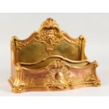 A GOOD FRENCH ORMOLU LETTER RACK, cast with a male mask and classical trophies, signed Rambaud. 14.