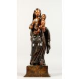 A CARVED AND PAINTED GROUP, "Madonna and Child", possibly 18th century, on a rectangular base. 17ins
