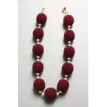 A SET OF ELEVEN MAROON CORAL BEADS NECKLACE.
