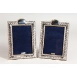 A PAIR OF SILVER SERPENTINE TOP PHOTO FRAMES. 7.5ins x 5.25ins.