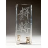 A MODERN SQUARE SHAPED GLASS VASE, etched with Chinese calligraphy. 10ins high.