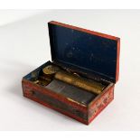 A SMALL MUSIC BOX, housed in a red Japanned case. 3.5ins long.