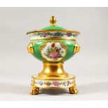 AN APPLE GREEN CIRCULAR SAUCE TUREEN AND COVER, edged in gilt and painted with flowers, supported on