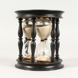 A TRIPLE HOURGLASS, with ebony stand. 3, 4 & 5 minute timers 5.5ins high.