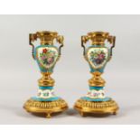 A GOOD PAIR OF SEVRES PORCELAIN AND ORMOLU CIRCULAR CANDLESTICKS, blue ground painted with