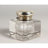 A HEAVY CUT GLASS INKWELL, with hinged silver top. 3.5ins wide.