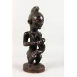 A CARVED TRIBAL MATERNITY FIGURE, possibly POTTER NATION. 16ins high.