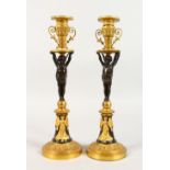 A VERY GOOD PAIR OF EMPIRE THOMAS HOPE DESIGN BRONZE AND ORMOLU CANDLESTICKS, with winged cupids, on