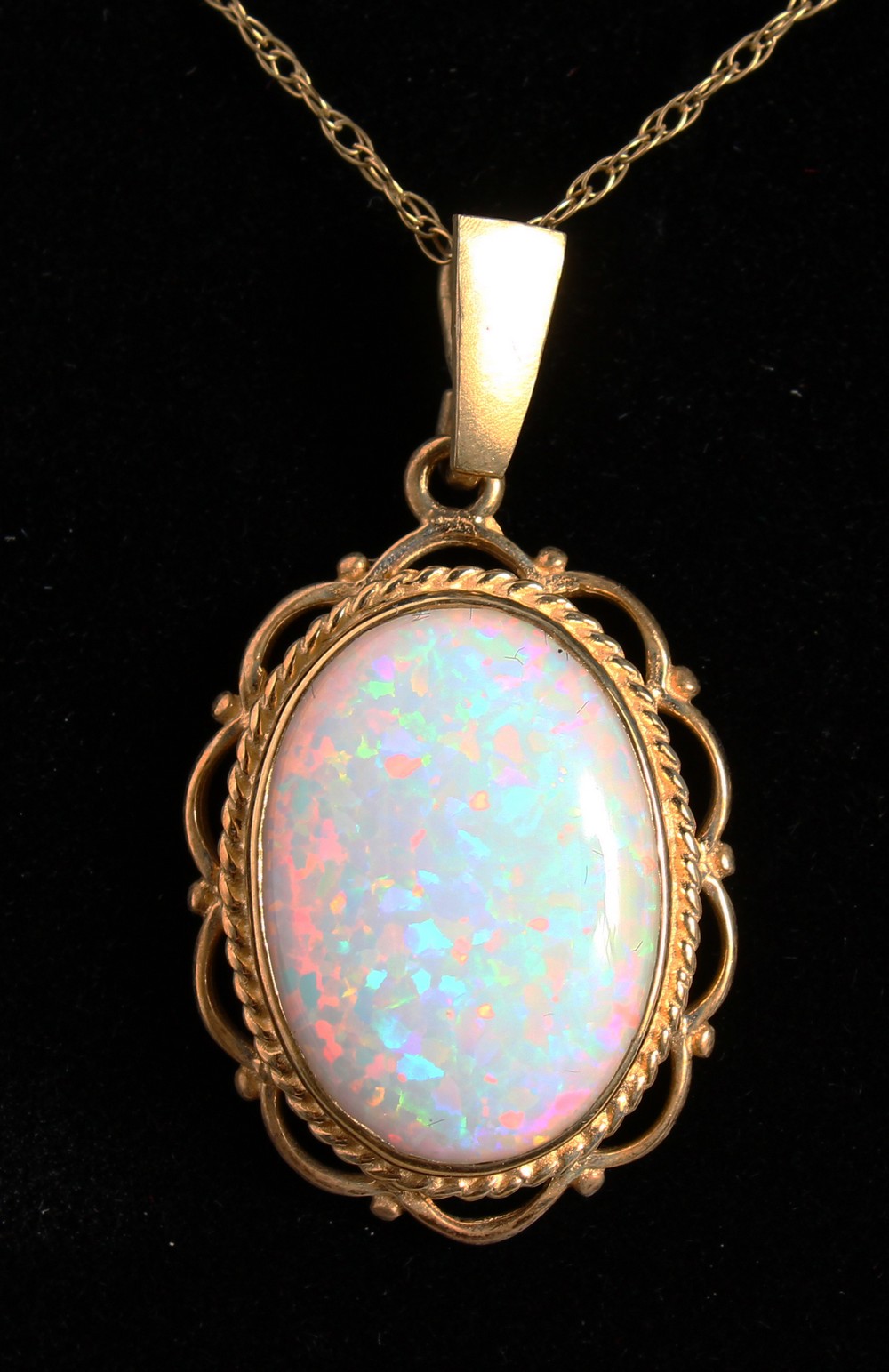 A 9CT GOLD OVAL OPAL PENDANT AND CHAIN.