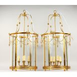 A GOOD LARGE PAIR OF BRASS CIRCULAR LANTERNS with glass shades, garlands and four candle sconces.