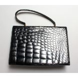 A LADIES BLACK CROCODILE LEATHER HANDBAG.