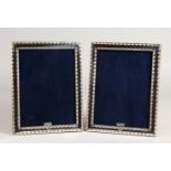 A PAIR OF SILVER BEAD EDGE PHOTO FRAMES. 9.25ins x 7ins.