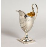 A GEIORGE III HERALDIC-SHAPE CREAM JUG, on a square base. Maker: FD & FC.