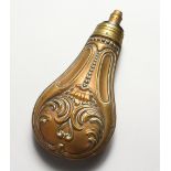 A COPPER POWDER FLASK, embossed with scrolling foliage. 6.75ins.