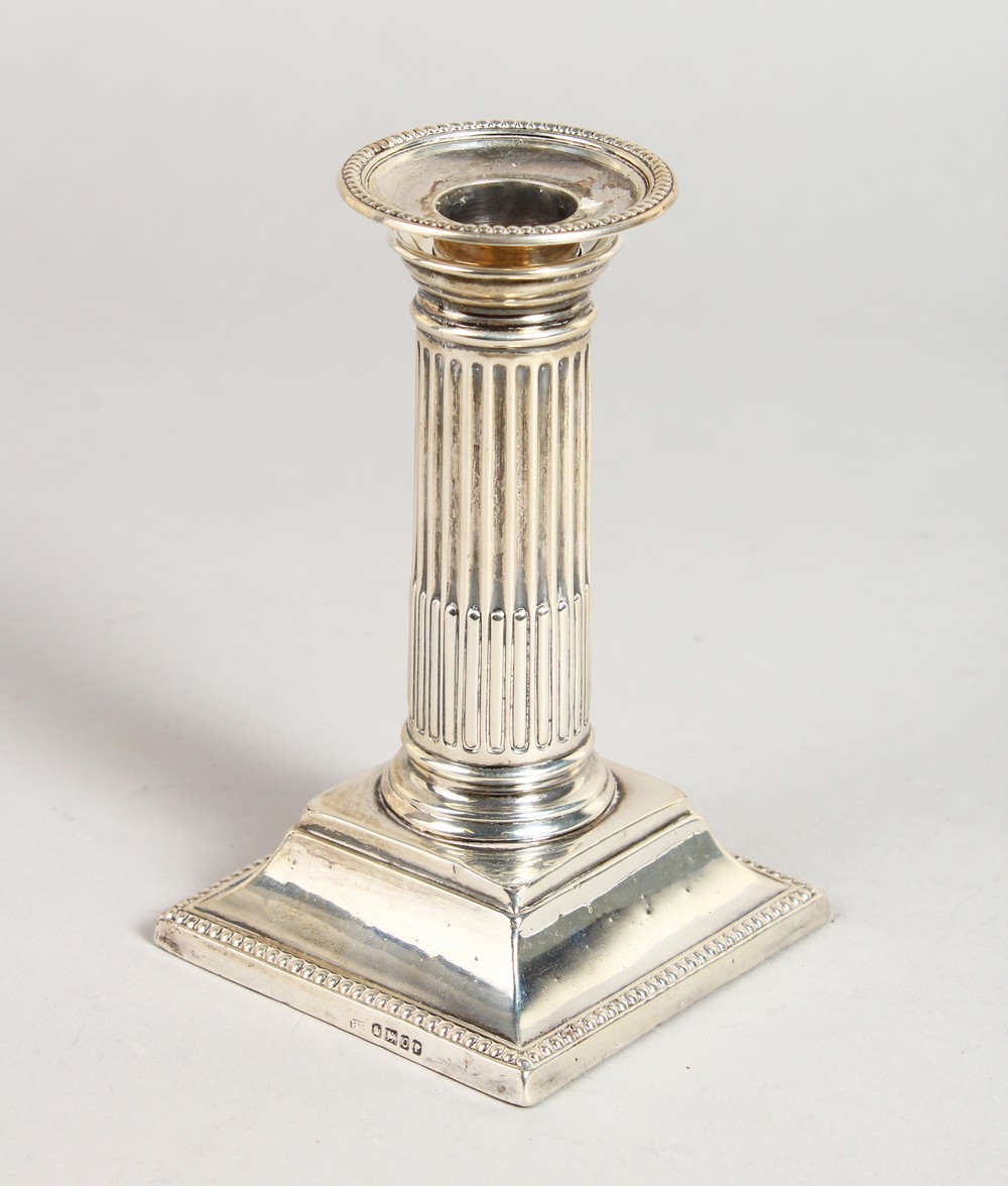 A VICTORIAN CANDLESTICK, with fluted columns, on a square base. 5ins high. Sheffield 1881. Maker: