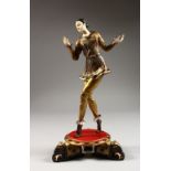A GILDED AND PAINTED BRONZE DANCER, with ivory hands and head, on a circular base. 12ins high.