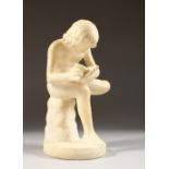 A CARVED ALABASTER FIGURE, a young man removing a thorn from his foot. 8.5ins high.