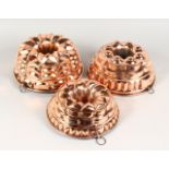 THREE GOOD LATE 19TH CENTURY COPPER JELLY MOULDS. 10ins and 11ins diameter.