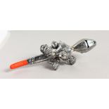 A SILVER AND CORAL BABIES RATTLE.