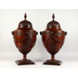 A VERY GOOD PAIR OF CHIPPENDALE DESIGN MAHOGANY CUTLERY URNS, with well carved rising tops, rams
