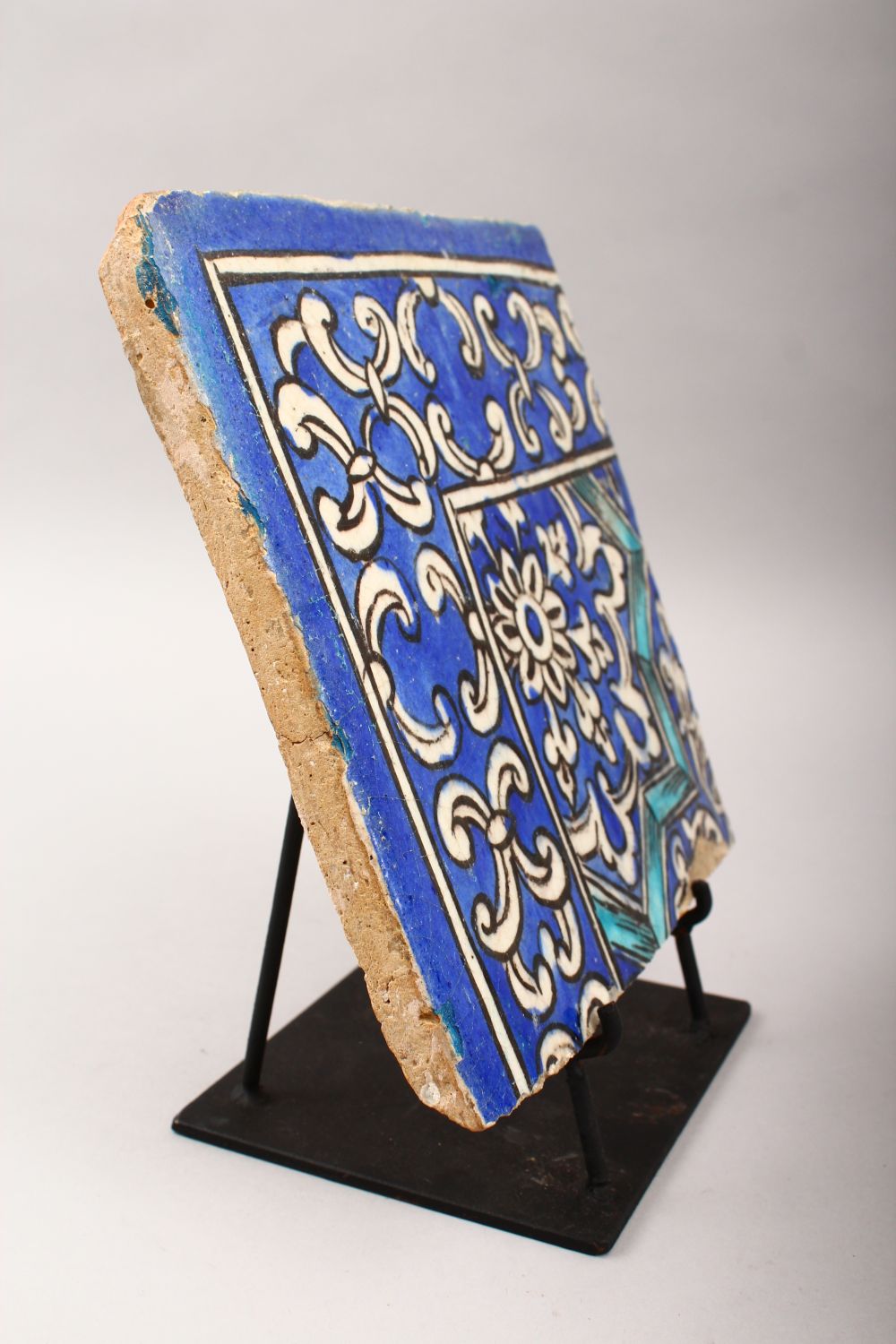 A 19TH CENTURY PERSIAN QAJAR BLUE AND WHITE CORNER TILE on a metal stand, tile 21.5cm x 21.5cm. - Image 7 of 11