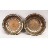 TWO GOOD EASTERN / ISLAMIC TINNED COPPER MOULDED DISHES, with ribbed decorations, 20cm diameter.