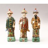 THREE 19TH / 20TH CENTURY CHINESE FAMILLE VERTE PORCELAIN FIGURES, each wearing hats with bead