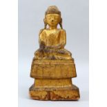 A GOOD 18TH CENTURY OR EARLIER GILT LACQUERED WOOD FIGURE OF A SEATED DEITY / BUDDHA. 32cm high x