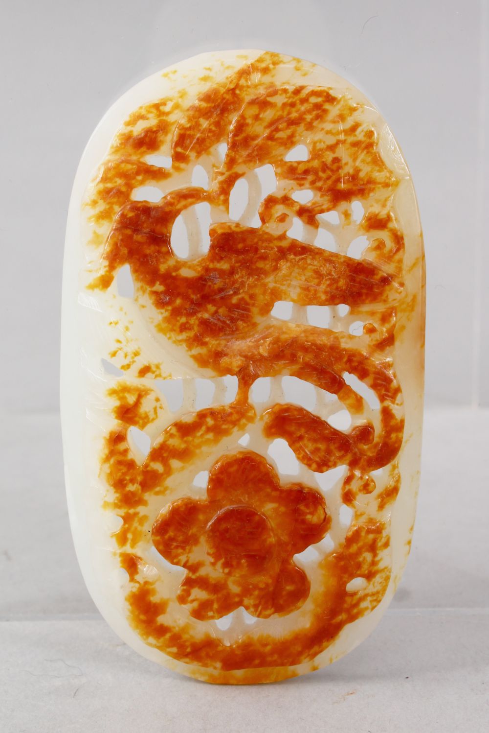 A GOOD QUALITY CHINESE CARVED WHITE JADE PENDANT / PEBBLE, carved to depict phoenix bird amongst