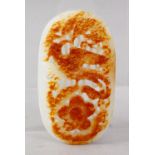 A GOOD QUALITY CHINESE CARVED WHITE JADE PENDANT / PEBBLE, carved to depict phoenix bird amongst
