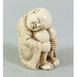 A JAPANESE MEIJI PERIOD CARVED IVORY OKIMONO OF A BOY, the boy in a seated position with his head