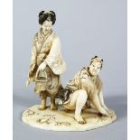 A GOOD JAPANESE MEIJI PERIOD CARVED IVORY OKIMONO - SHELL COLLECTORS, the male and female figure