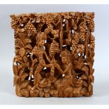 AN INDIAN CARVED RELIEF PANEL OF TWO FIGURES, the figures carved in relief around native foliage,