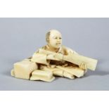 A JAPANESE MEIJI PERIOD CARVED IVORY OKIMONO OF AN ARTISAN, in a seated position working with his