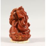 A 20TH CENTURY INDIAN GOLD STONE / GLASS FIGURE OF GANESH, fixed to a carved jade / soapstone