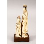A 19TH CENTURY JAPANESE CARVED IVORY FIGURE OF TWO FEMALE FIGURES, both stood in traditional