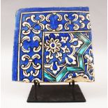 A 19TH CENTURY PERSIAN QAJAR BLUE AND WHITE CORNER TILE on a metal stand, tile 21.5cm x 21.5cm.