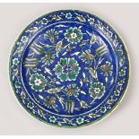AN ISLAMIC PALISTINE IZNIK STYLE POTTERY PLATE, with floral decoration on blue ground, 22.5cm