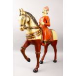 A LARGE INDIAN CARVED WOOD AND POLYCHROMED FIGURE OF A MAN ON HORSEBACK, 61cm, 77cm high.