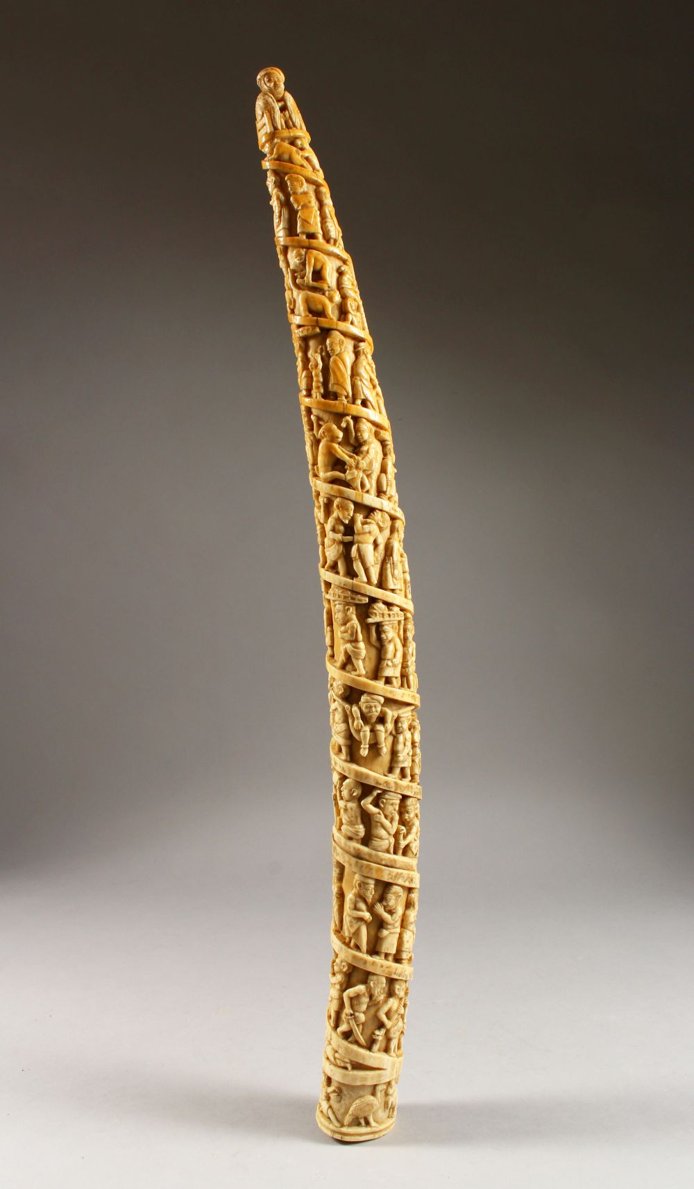 A 19TH CENTURY OR EARLIER ETHNIC / ASIAN CARVED IVORY TUSK SECTION, profusely carved with scenes