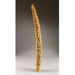 A 19TH CENTURY OR EARLIER ETHNIC / ASIAN CARVED IVORY TUSK SECTION, profusely carved with scenes