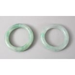 TWO GOOD CHINESE CARVED JADE BANGLES, 8cm diameter with an internal measurement of 5cm.