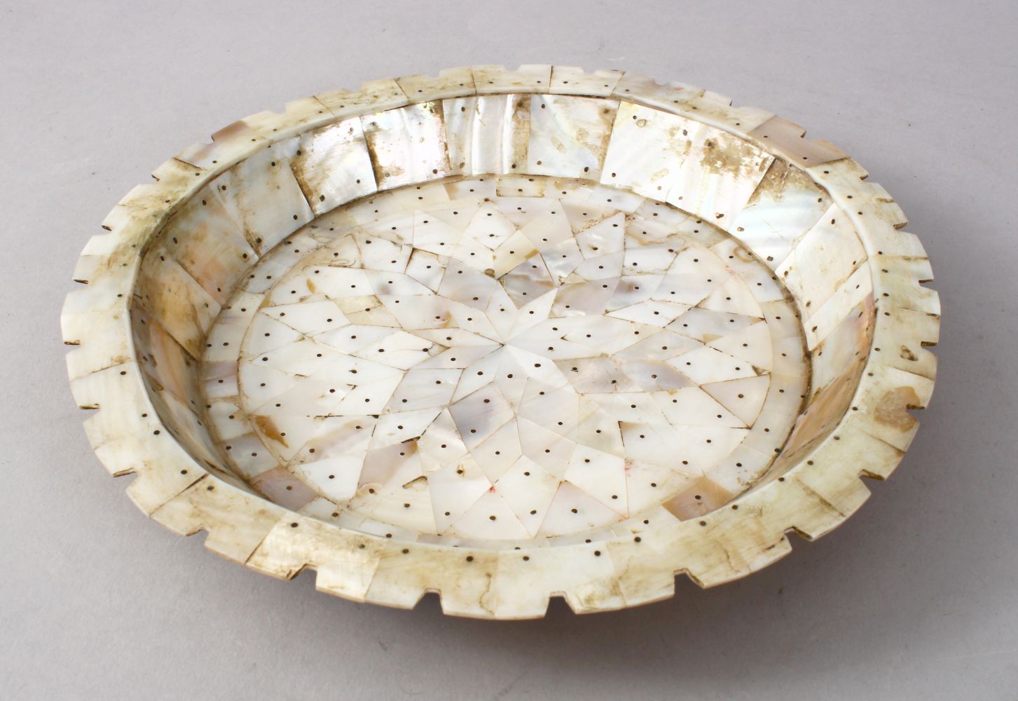 A GOOD 18TH / 19TH CENTURY GOA MOTHER OF PEARL DISH, the dish formed from sectional cuts of mother